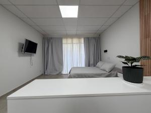 a white room with a bed and a tv at Departamentosenchascomus in Chascomús