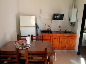 a kitchen with a wooden table and a refrigerator at Ohana PGB - Se requiere seña para confirmar in Gualeguaychú