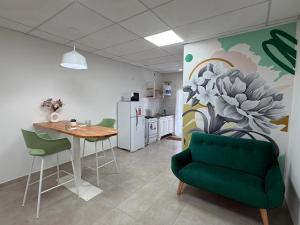a living room with a table and a green couch at Departamentosenchascomus in Chascomús