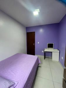 a bedroom with a bed and a desk with a computer at Casa de Praia in Capão da Canoa +2 photos