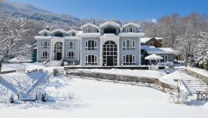 ein großes weißes Haus im Schnee in der Unterkunft Forest Hill Resorts in Pahalgām