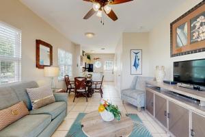 een woonkamer met een bank en een tv bij Jewel in the Sea in Duck Key