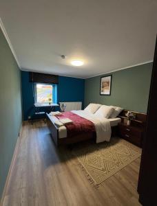 a bedroom with a bed with blue walls and a rug at Famenne Escape in Marche-en-Famenne