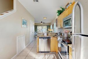 een keuken met houten kasten en een roestvrijstalen koelkast bij Jewel in the Sea in Duck Key