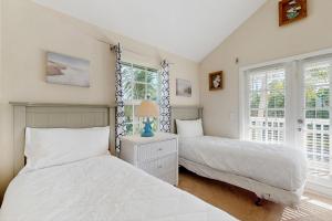 twee bedden in een slaapkamer met twee ramen bij Jewel in the Sea in Duck Key +16 foto's