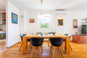 a kitchen and dining room with a wooden table and chairs at Villa Dome in Slatine