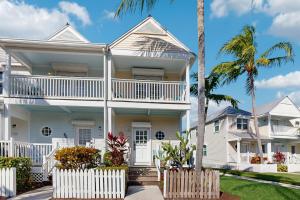 een wit huis met palmbomen ervoor bij Jewel in the Sea in Duck Key