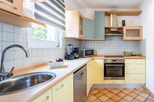 a kitchen with yellow cabinets and a sink at Villa Dome in Slatine +22 photos