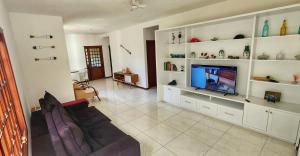 een woonkamer met een bank en een televisie bij Casa Maré Floripa - Coliving, Coworking and Community in Florianópolis