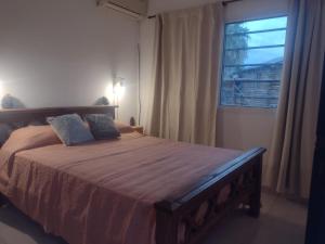 una camera da letto con un letto grande con una finestra di Ohana PGB a Gualeguaychú