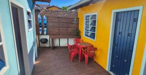 een patio met rode stoelen en een tafel en een gebouw bij Casa Maré Floripa - Coliving, Coworking and Community in Florianópolis +25 foto's