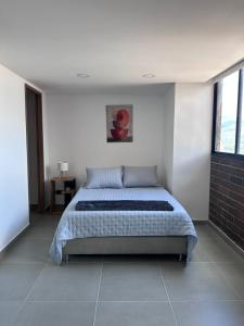 a bedroom with a bed and a brick wall at Sabaneta, aparta Loft, excelente Ubicacion, Wifi in Sabaneta