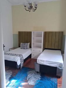 een slaapkamer met twee bedden en een ladekast bij Imany house in Kaapstad