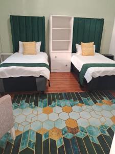 een slaapkamer met 2 bedden en een tapijt bij Imany house in Kaapstad