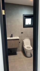 ein Badezimmer mit Toilette und Waschbecken und einem Fenster in der Unterkunft Increíble casa con vista al lago in Licán Ray