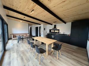 eine Küche und ein Esszimmer mit einem Holztisch und Stühlen in der Unterkunft Increíble casa con vista al lago in Licán Ray + 13 Fotos