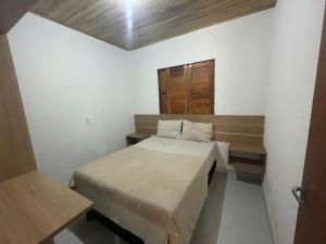 una piccola camera con letto e porta in legno di Flats da Ilha Max Rev a Marechal Deodoro