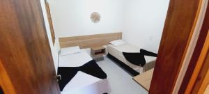 una piccola camera con due letti e una porta di Flats da Ilha Max Rev a Marechal Deodoro Altre 5 foto