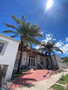 una casa con dos palmeras delante de ella en Posada del Arbol, en Capilla del Monte 42 fotos más