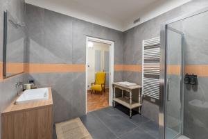 a bathroom with a sink and a yellow chair at Nidin Apartments in Cassano Spinola