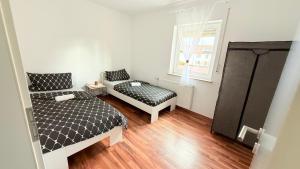 une chambre avec deux lits et une fenêtre dans l'établissement Apartment Unterkunft Baron, à Fürth
