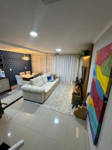 een woonkamer met een bank en een tafel bij Triplex in Village - Santos SP in Santos