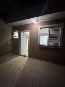 een lege kamer met een deur en een raam bij Triplex in Village - Santos SP in Santos