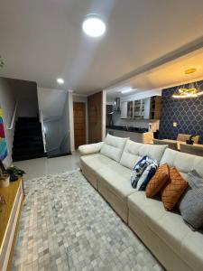 een woonkamer met een witte bank en een keuken bij Triplex in Village - Santos SP in Santos