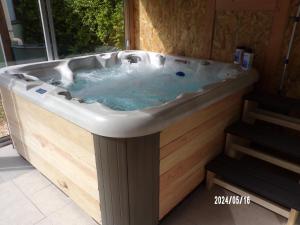 une baignoire jacuzzi dans une chambre avec fenêtre dans l'établissement Le Mas Hauregard, à La Celle-sous-Gouzon