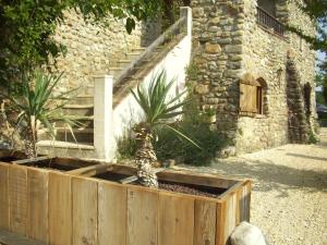 une jardinière en bois devant un bâtiment en pierre dans l'établissement Le Mas Hauregard, à La Celle-sous-Gouzon