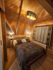 a bedroom with a large bed in a wooden ceiling at Apartamenty SKUPNIOWY UPŁAZ in Murzasichle
