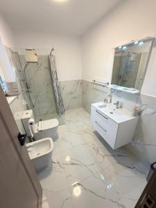 a bathroom with a sink and a toilet and a mirror at Cameră dublă Suceava in Ipoteşti
