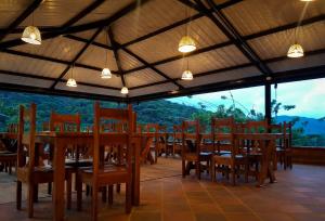 a restaurant with a long table with chairs and a view at Ecolodge Ix Cacao in San Carlos