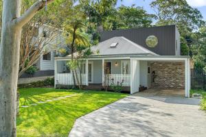a white house with a gray roof at Bundeena Bungalow in Bundeena