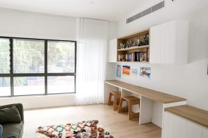 a living room with a desk and a window at Bundeena Bungalow in Bundeena