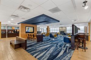 een kantoorlobby met een eetgedeelte en tafels en stoelen bij Comfort Inn & Suites in Watervliet