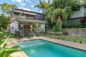 a backyard with a swimming pool and a house at Bundeena Bungalow in Bundeena