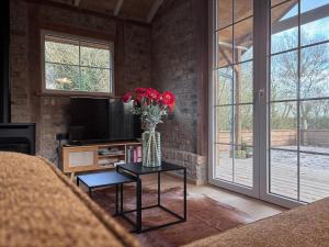 a living room with a vase of flowers on a table at Idyllic cottage with wellness facilities in Alveringem
