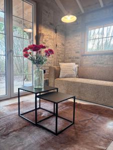 een woonkamer met een bank en een tafel met een vaas met bloemen bij Idyllic cottage with wellness facilities in Alveringem