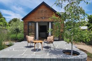 a patio with chairs and a table and a tree at Sage in Glenlyon