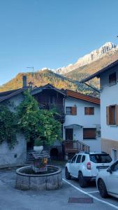 twee auto's geparkeerd op een parkeerplaats voor een gebouw bij Casa Mia in Agordo