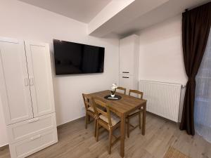 a dining room table with chairs and a tv on the wall at The View Studio 2 Busteni in Buşteni +5 photos