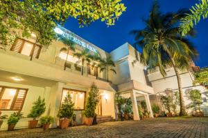 a building with a palm tree in front of it at Tissa's Inn in Cochin