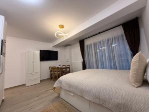 a bedroom with a bed with a window and a table at The View Studio 2 Busteni in Buşteni