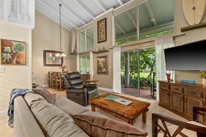 ein Wohnzimmer mit Sofa und Fernseher in der Unterkunft (P9B) 1Br with Loft Princeville Retreat, Pool, AC, Wifi in Puupehu