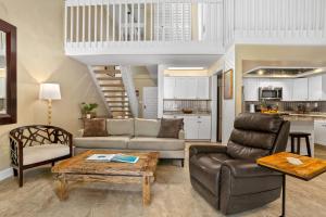 ein Wohnzimmer mit Sofa und Tisch in der Unterkunft (P9B) 1Br with Loft Princeville Retreat, Pool, AC, Wifi in Puupehu