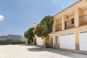 a house with white garage doors on a street at El Calar - Casas Rurales Luis in Moratalla