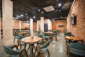 a restaurant with tables and chairs and a brick wall at Steel Tower Borjomi in Borjomi