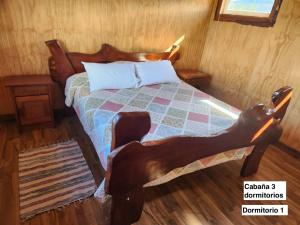 a bedroom with a bed in a wooden room at Turismo Raíces in Coihaique