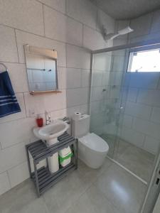een badkamer met een toilet, een wastafel en een douche bij Rooftop BeiraMar in Balneario Barra do Sul